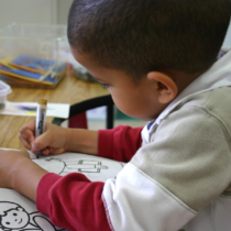 Young boy coloring at a desk