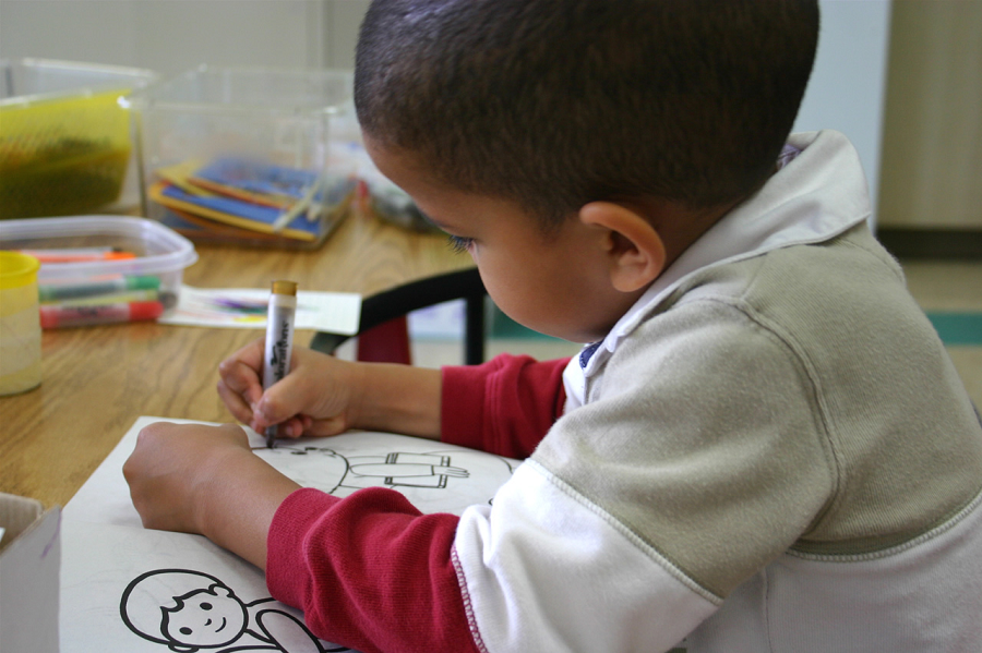 Young boy coloring at a desk